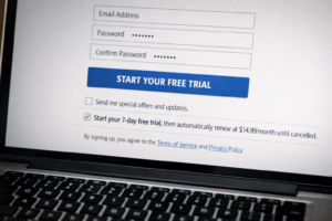 A website sign-up form with a pre-ticked subscription auto-renewal checkbox buried in the small print, representing dark pattern design tactics.