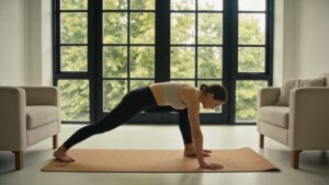 A dedicated morning wellness space showing an individual performing gentle functional mobility movements on a sustainable yoga mat.