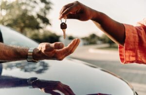 A successful price negotiation and keys being handed over for a pre-owned vehicle purchase.
