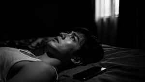 Person lying awake at night showing one of the common signs of chronic stress