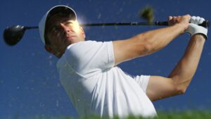 A golfer at the top of the backswing showing safe wrist hinge and a centered, stable hip rotation
