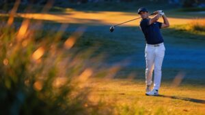 A golfer standing in a perfectly balanced, tall finish position after safely striking the golf ball.