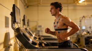 A professional sports performance clinic tracking an athlete's physical metrics and running posture on a modern treadmill setup.