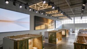 An eco-conscious indoor exhibition hall setup utilizing digital display boards and sustainable bamboo display booths.