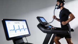 An elite competitor undergoing a metabolic VO2 max assessment using a specialized breathing mask on a treadmill.
