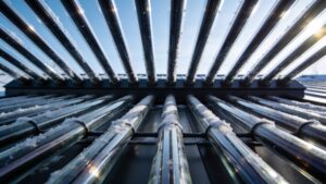 High-performance evacuated tube solar thermal collectors mounted on a modern standing-seam residential roof structure.
