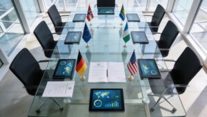 Environmental policy documents and digital tablets laid out on a glass desk at an international summit.