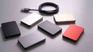 Five portable SSD drives arranged on a desk, representing different storage options"