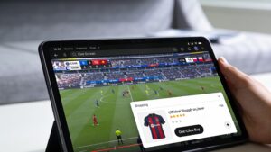 Digital tablet running a live sports stream with an interactive in-player merchandise checkout popup.