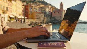 Person working remotely on a laptop at an outdoor café in a European town