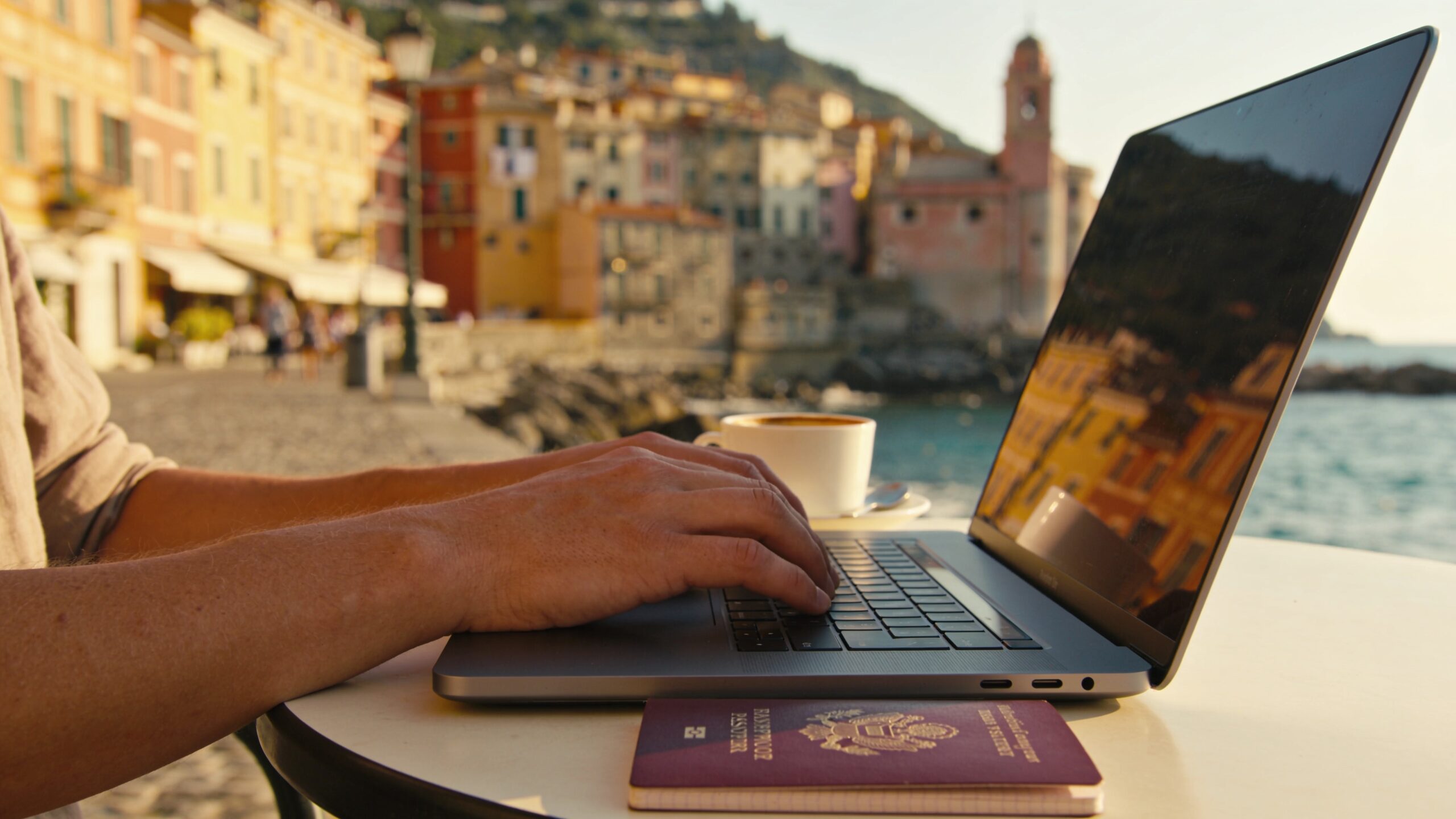 Person working remotely on a laptop at an outdoor café in a European town
