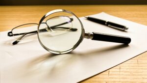 Magnifying glass over a sheet of paper on a desk.