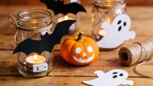 Handmade Halloween decorations, including paper bats, mason jar lights, and a painted pumpkin.