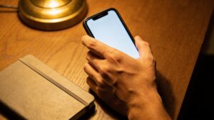 Person pausing over a phone before replying to an appeal.